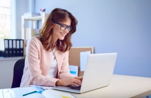 Happy woman working on her laptop from home office